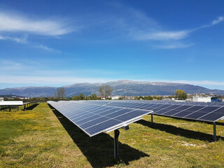 solar panels solar energy in a green meadow and blue bright sky