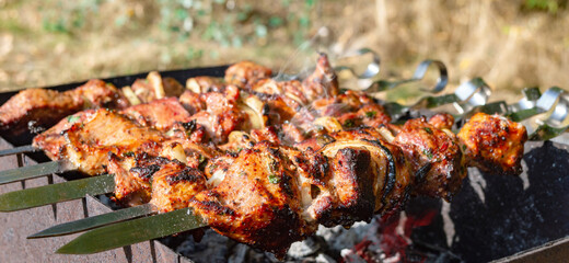 Fototapeta premium Juicy meat with onion on metal skewers on the grill.