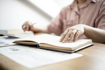 Women are doing income and expenditure accounts to divide their money into savings and to buy funds to grow. Concept of saving money and investing.