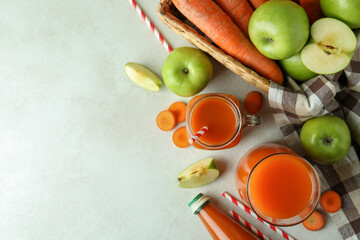 Apple - carrot juice and ingredients on white textured table, top view