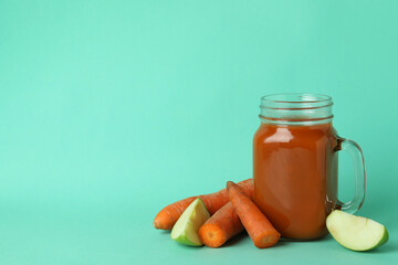 Glass jar of juice and ingredients on mint background