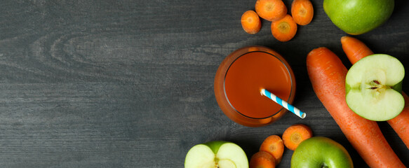 Glass of juice and ingredients on dark wooden background