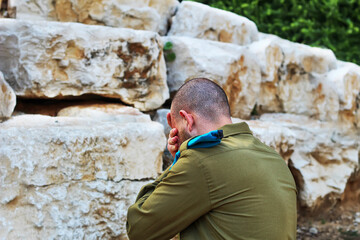 Obraz na płótnie Canvas Israeli soldier crying in front of the graves of fallen soldiers. Concept: Israeli soldiers, Israel Memorial Day - Yom HaZikaron, Holocaust Remembrance Day - Yom hashoah, Israel Independence Day