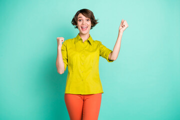 Portrait of attractive cheerful girl having fun rejoicing good luck isolated on bright blue color...