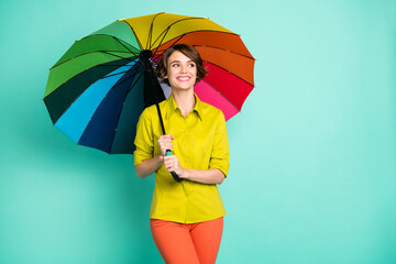 Photo portrait of smiling woman looking empty space keeping big colorful umbrella isolated on...