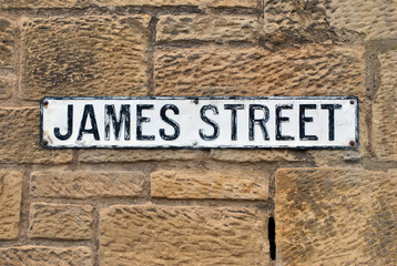 Cast Iron Street Name Plate on Old Rugged Textured Stone Wall