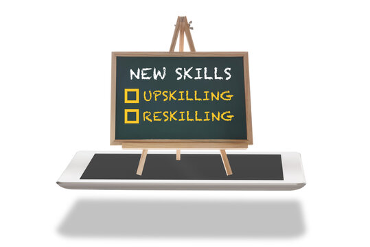 New skills reskilling and upskilling written on chalkboard on computer tablet. Electronic learning development concept and digital transformation and disruption idea