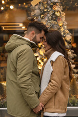 Fototapeta premium Lovely couple near store decorated for Christmas outdoors