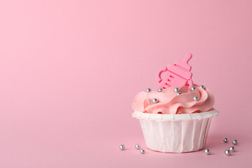 Baby shower cupcake with topper on pink background, space for text