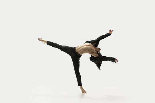 Man in casual style clothes jumping and dancing isolated on white background. Art, motion, action, flexibility, inspiration concept. Flexible caucasian ballet dancer.