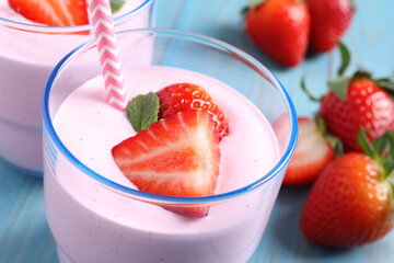 Delicious drink with strawberries in glass on table, closeup