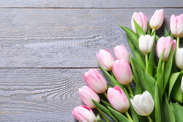 Obraz na płótnie Canvas Beautiful pink spring tulips on grey wooden background, flat lay. Space for text