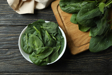Bowl of fresh spinach on rustic wooden table