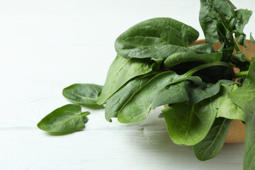 Bowl of spinach on white wooden background