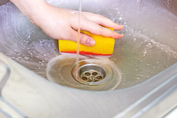 Cleaning metal sink with chemicals and sponge. Housework, housekeeping service, household duties...