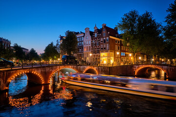 Fototapeta na wymiar Amterdam canal, bridge and medieval houses in the evening