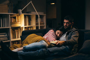 young couple watching television together at home