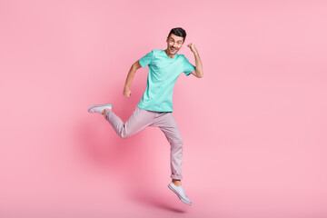 Fototapeta na wymiar Full body photo of young excited man go run jump rejoice victory fists hands isolated over pastel color background