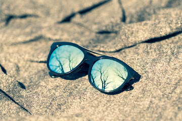 Fashion Sunglasses design with blue lenses shoot outside in a summer day closeup. Selective focus....