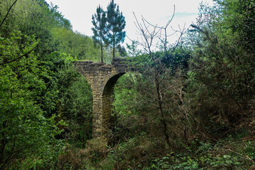 Fototapeta na wymiar San Sebastian, Spain - April 15, 2021: Ancient stone Aquaduct on a coastal path in the Basque country