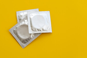 Safe sex concept. Condoms on a yellow background. A place for your design.