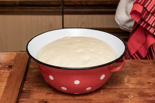 Yeast dough rose in a large metal bowl