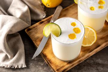 Pisco sour cocktail on wooden table. Traditional peruvian cocktail