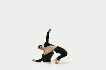 Man in casual style clothes jumping and dancing isolated on white background. Art, motion, action, flexibility, inspiration concept. Flexible caucasian ballet dancer.