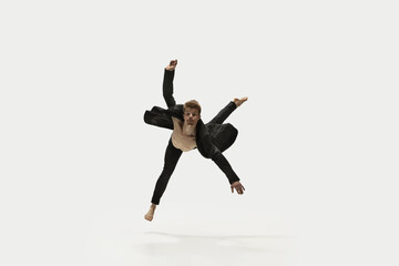 Fototapeta na wymiar Man in casual style clothes jumping and dancing isolated on white background. Art, motion, action, flexibility, inspiration concept. Flexible caucasian ballet dancer.