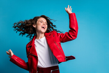 Photo of optimistic cool girl dance wear red jacket isolated on blue color background