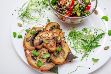 Sandwich with fried mushrooms, basil, pumpkin seeds and microgreens - radish and onion seedlings and tomato and cucumber salad, served with sesame seeds.