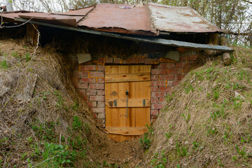 A dugout with a wooden door and a brick wall in the pit