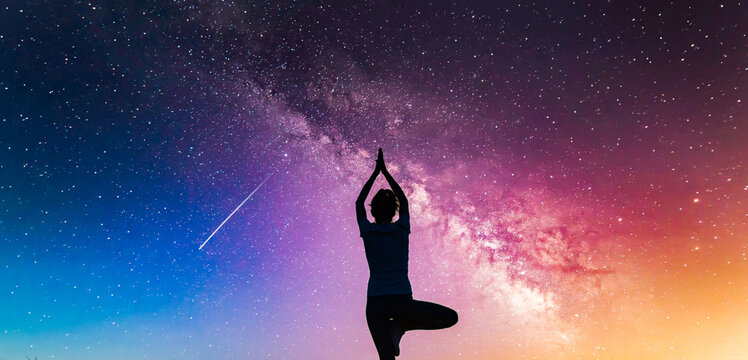 woman doing yoga under night sky with stars spirituality