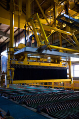 Fototapeta na wymiar Copper metallurgical plant. Overhead crane of electrolysis machine lifting ready copper ingots.
