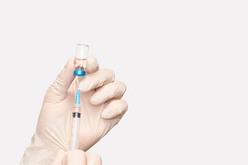 Doctor holding bottle with injection in blue glove hands. Pharmacy laboratory flu concept. Vitamin syringe glass vial. Medicine nurse treatment. Beauty cosmetology needle injector ampoule