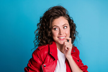 Photo of adorable curly hairstyle cheerful person biting finger nail look empty space isolated on blue color background