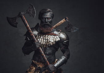 Fearful and muscular warrior with scorched skin and double axe