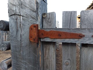 Wooden Fence Door View with Weathered Wall Planks, Old Rusty Hinges and Chains. Agricultural Livestock Building Tree Texture Background