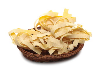 Raw pappardelle pasta pile in woven wicker basket isolated on white background