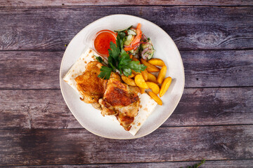 fried chicken with potatoes in a white plate
