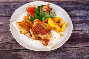 fried chicken with potatoes in a white plate
