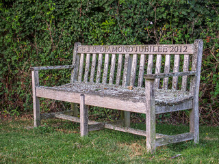 Wooden bench in rural village setting commemorating Queen Elizabeth the Second Diamond Jubilee 2012