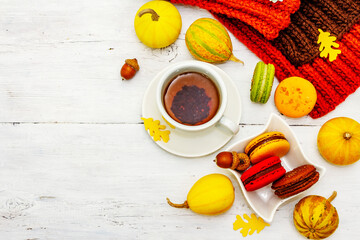 French macarons in autumn colors with cup of hot tea