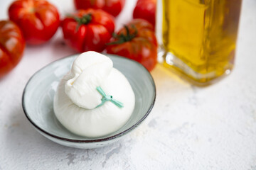 Burrata cheese, tomatoes and olive oil to make a traditional italian salad.