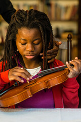 girl practicing and learning violin play at home
