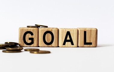 wooden cubes and GOAL, coins, the concept of taxation, increase taxes and fees