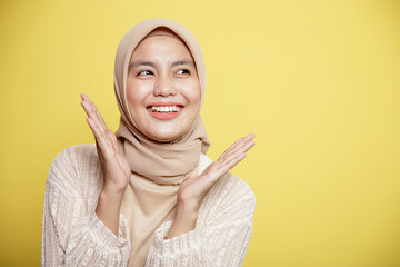 close up beautiful hijab female applause smile expression very excited isolated on a yellow...