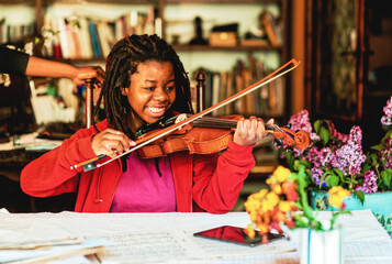 girl practicing and learning violin play at home
