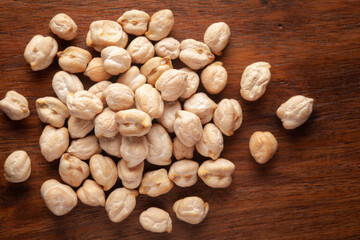 Macro Close-up of Organic chhole chana or Kabuli chana (Cicer arietinum) or whole white Bengal gram dal cleaned on wooden top background.
