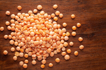 Macro Close-up of Organic masoor dal (Lens culinaris) or whole pink dal cleaned on wooden top...